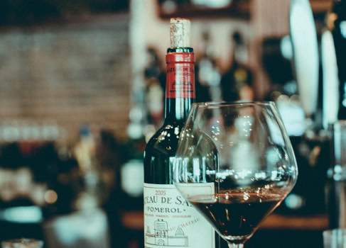 Wine bottle and glass of rosé wine in a cozy restaurant setting.